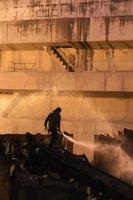 Silhouettes of  firemen before a fire photo