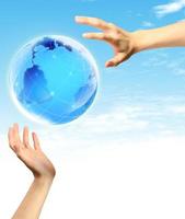 Globe in human hand against blue sky. photo