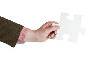 male hand holding big white paper puzzle piece photo