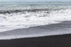 ocean surf on Reynisfjara black beach in Iceland photo