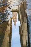 tower of church reflected in puddle photo