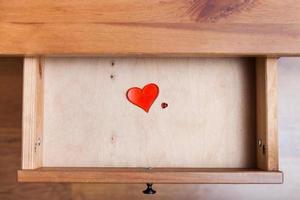 two red glass hearts in open drawer photo