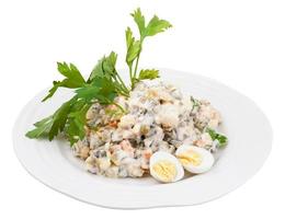 olivier russian salad decorated with herb and eggs photo