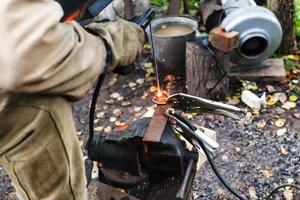 Welder welds iron ring by spot electric welding photo