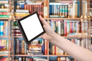 hand holds tablet pc in library background photo