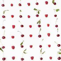 many raspberries and cherries arranged on square photo