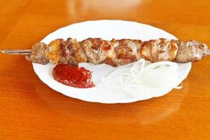 skewer of lamb shishkebab on white plate photo