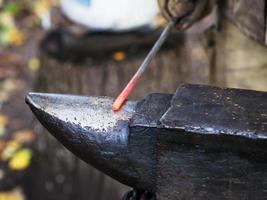 red hot iron rod on anvil photo