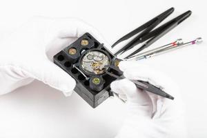 repairing of mechanical watch with tweezers photo