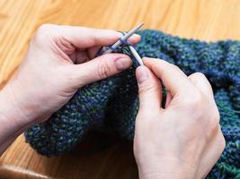 female hands knit pullover from wool close up photo