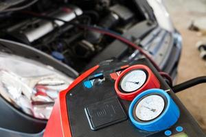Refilling of car conditioner in auto repair shop photo