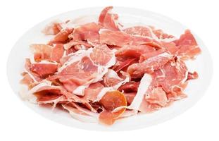 many slices of dry-cured ham on plate isolated photo