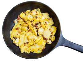 black frying pan with fried potatoes and bacon photo