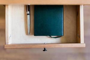 pen and notebook in open drawer photo