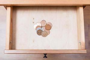 several of british coins in open drawer photo