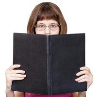 chica con gafas mira un gran libro aislado foto