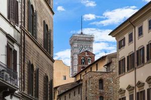 Campanile and bell tower over urban houses photo