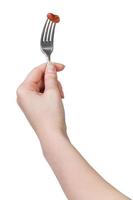 hand holding dinning fork with impaled brown bean photo