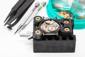 soporte con reloj y herramientas para reparar reloj foto