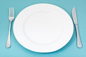 empty white plate with fork and knife on green photo