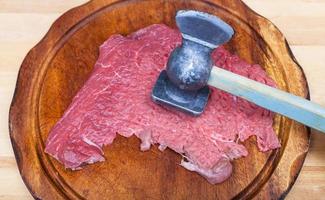 slice of veal are beat by meat tenderizer photo