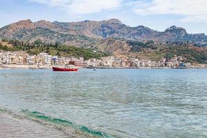 boat in sea near waterfront of Giardini Naxos photo