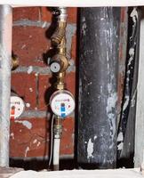 residential water meters on pipes in niche photo