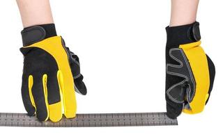 worker hands in safety gloves with ruler isolated photo