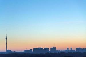 clear blue and yellow daybreak sky over city photo