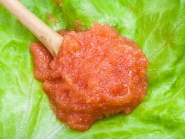 caviar of whitefish in wood spoon on green lettuce photo