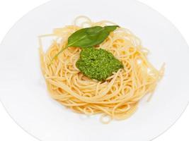 spaghetti with pesto on white plate photo