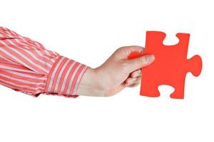 male hand holding big red paper puzzle piece photo