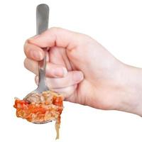 hand holding tablespoon with cabbage soup isolated photo