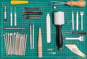 various tools for leathercraft on self-healing mat photo