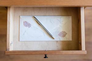 silver pen on vintage envelope in open drawer photo