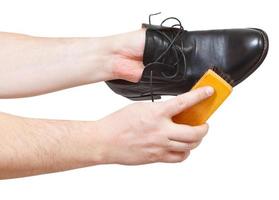 Shoeshiner cleaning black shoes by brush photo