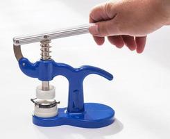 hand holds handle of manual press for wristwatch photo