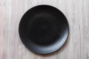 top view of black plate on gray brown table photo