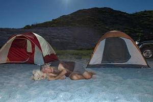 hombre y perro en el campamento de la noche en el desierto foto