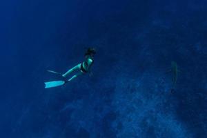 gente buceando con tiburones en el océano azul de polinesia foto