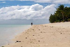 hombre y mujer caminando en la playa de polinesia foto