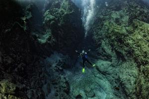 Scuba diver underwater in the deep blye ocean abyss photo
