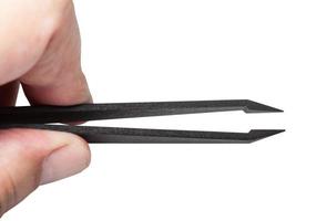 fingers hold plastic tweezers with sharp tips photo