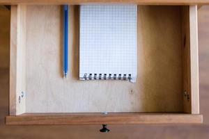 modern pen and squared notebook in open drawer photo