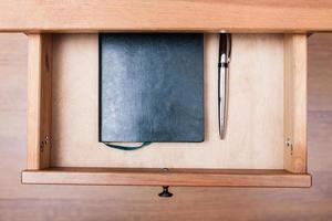 modern pen and notebook in open drawer photo