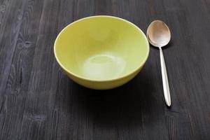 green bowl and spoon on dark brown board photo