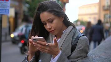 mulher ocupada na rua com smarthphone video