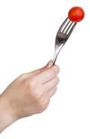 hand holding fork with one fresh red cherry tomato photo