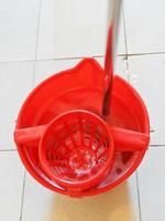 mop in red bucket with washing water photo