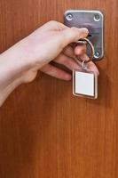 cerrar la puerta de casa con llave con llavero en blanco foto
